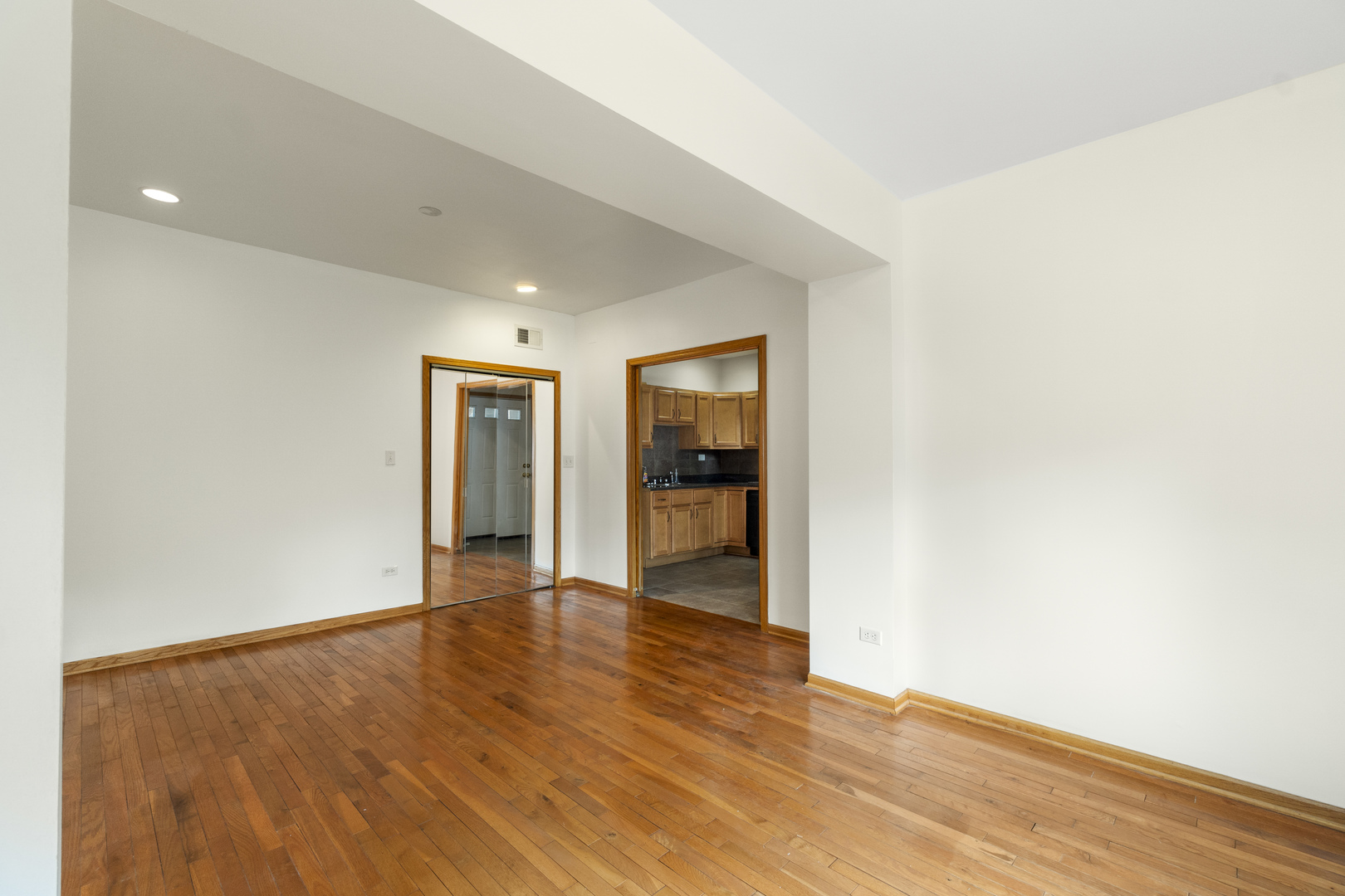 7223 North Damen Avenue Chicago, IL 60645 - Photo 17 of 37 a view of an empty room with wooden floor and a window