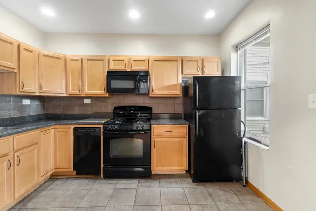 a kitchen with stainless steel appliances granite countertop a refrigerator and a sink