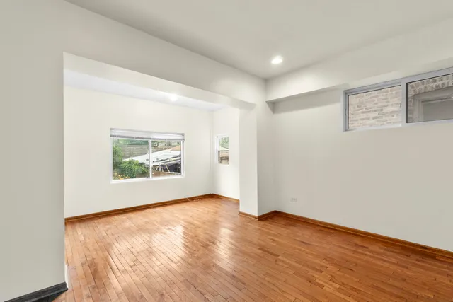 an empty room with wooden floor and window