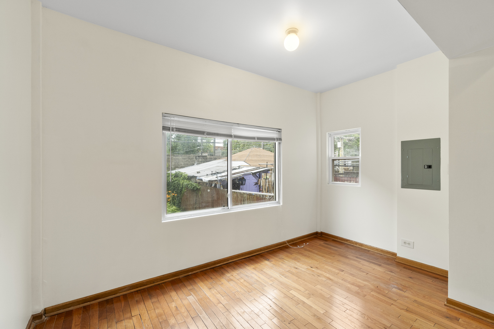 7223 North Damen Avenue Chicago, IL 60645 - Photo 22 of 37 an empty room with wooden floor and windows