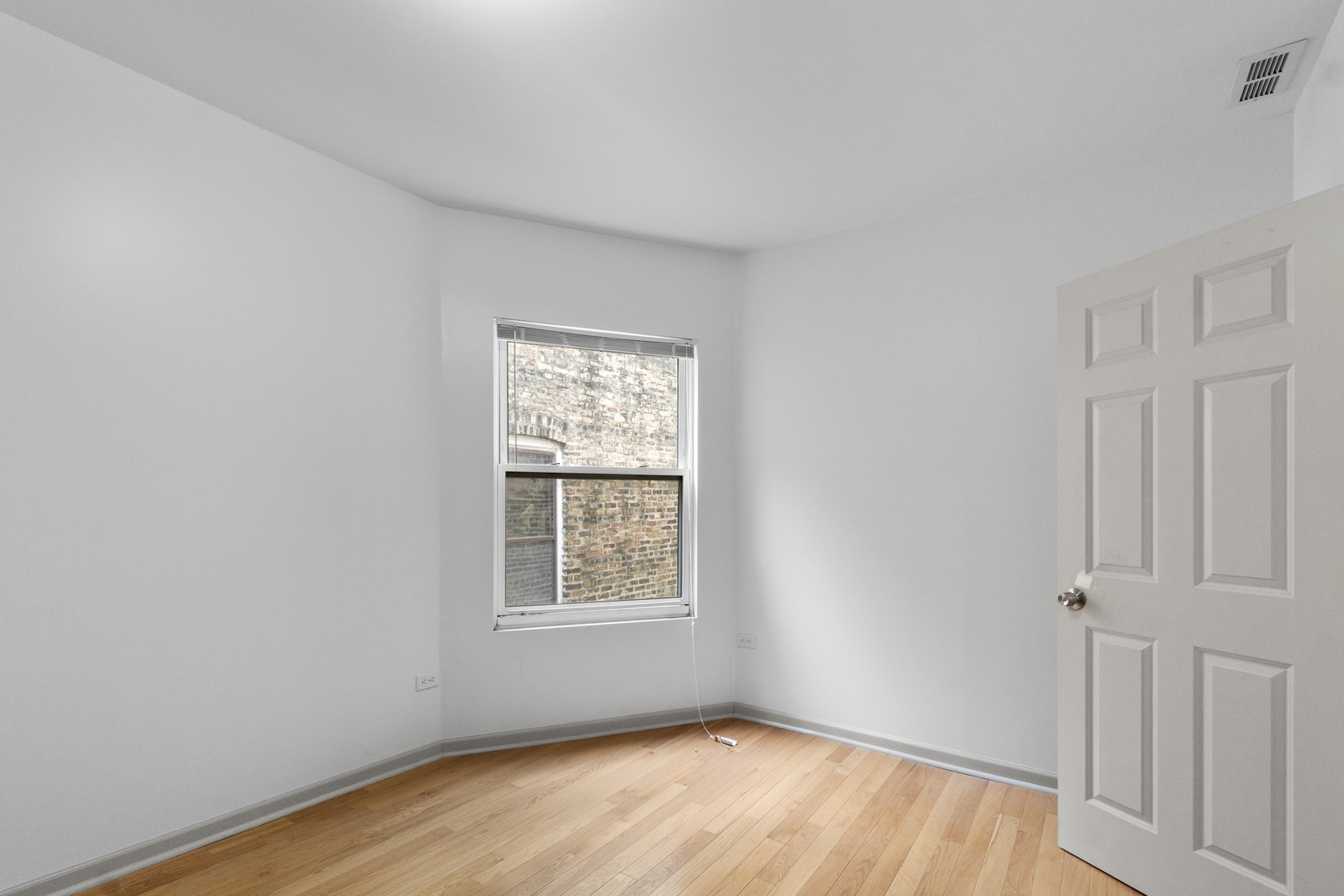 7223 North Damen Avenue Chicago, IL 60645 - Photo 26 of 37 an empty room with wooden floor and windows