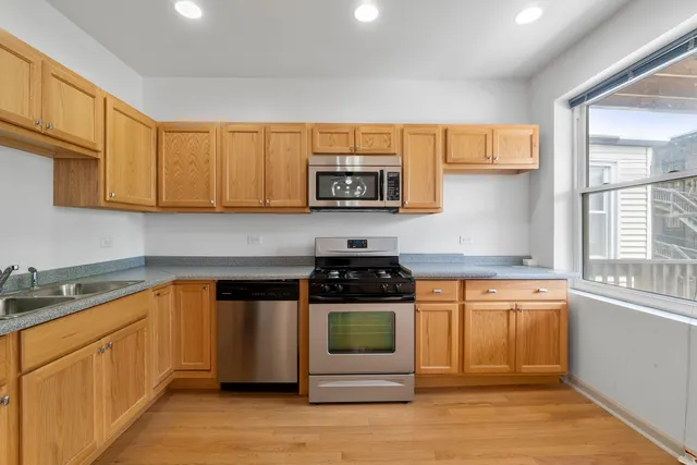 a kitchen with stainless steel appliances granite countertop a stove a sink and a microwave