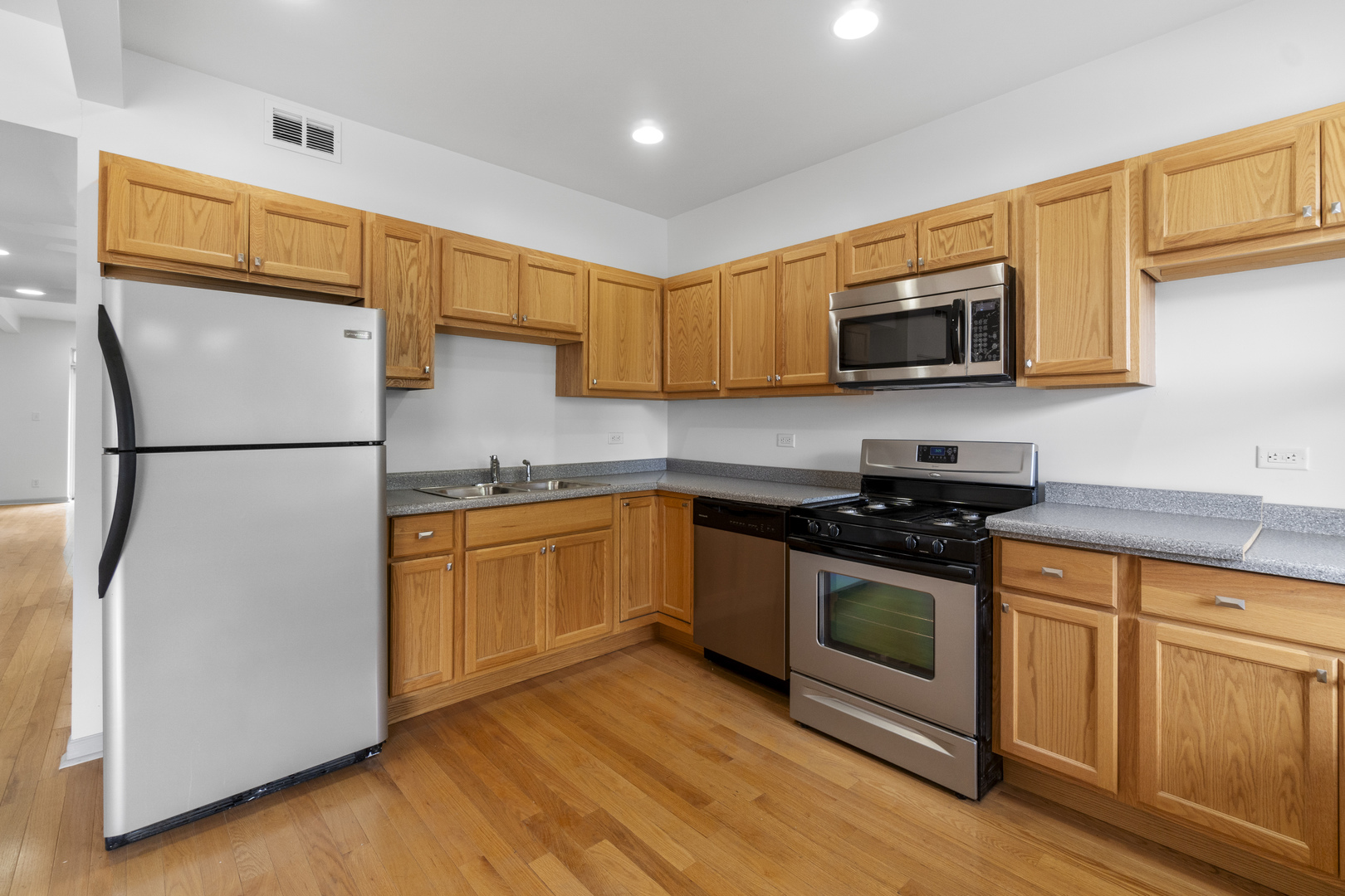 7223 North Damen Avenue Chicago, IL 60645 - Photo 31 of 37 a kitchen with stainless steel appliances granite countertop a refrigerator stove a sink and a microwave