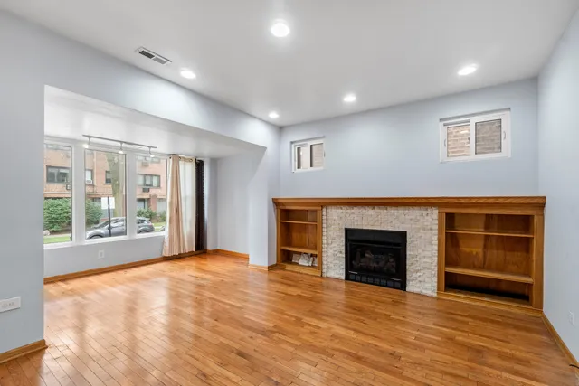 a view of an empty room with a fireplace and a window