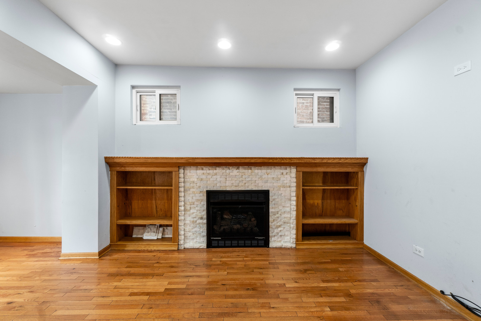 7223 North Damen Avenue Chicago, IL 60645 - Photo 6 of 37 an empty room with wooden floor fireplace and windows