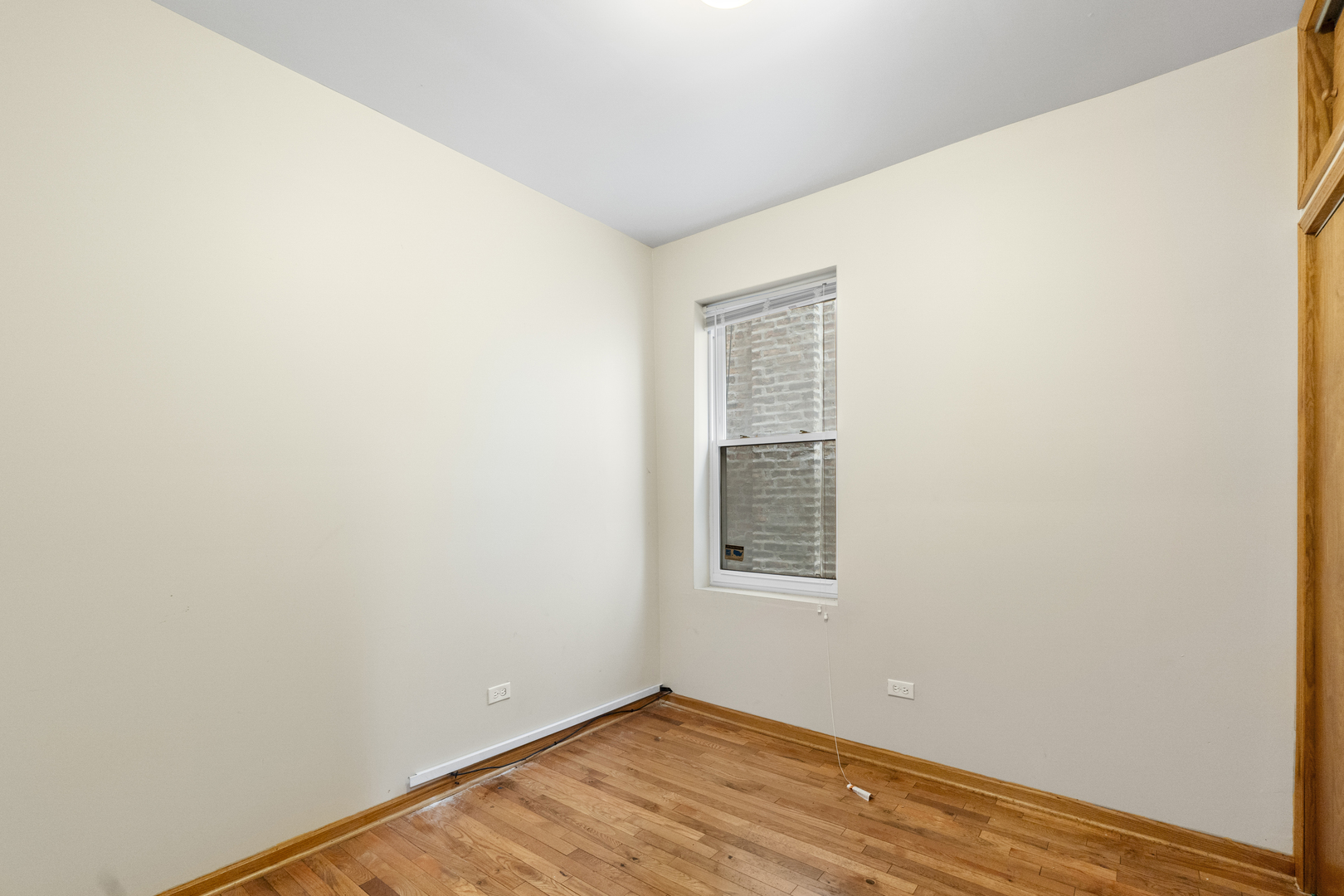 7223 North Damen Avenue Chicago, IL 60645 - Photo 9 of 37 a view of an empty room with wooden floor and a window