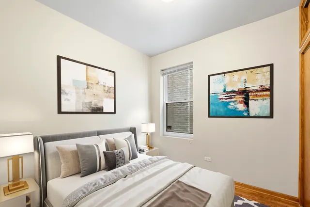 a bedroom with a bed and a painting on the wall