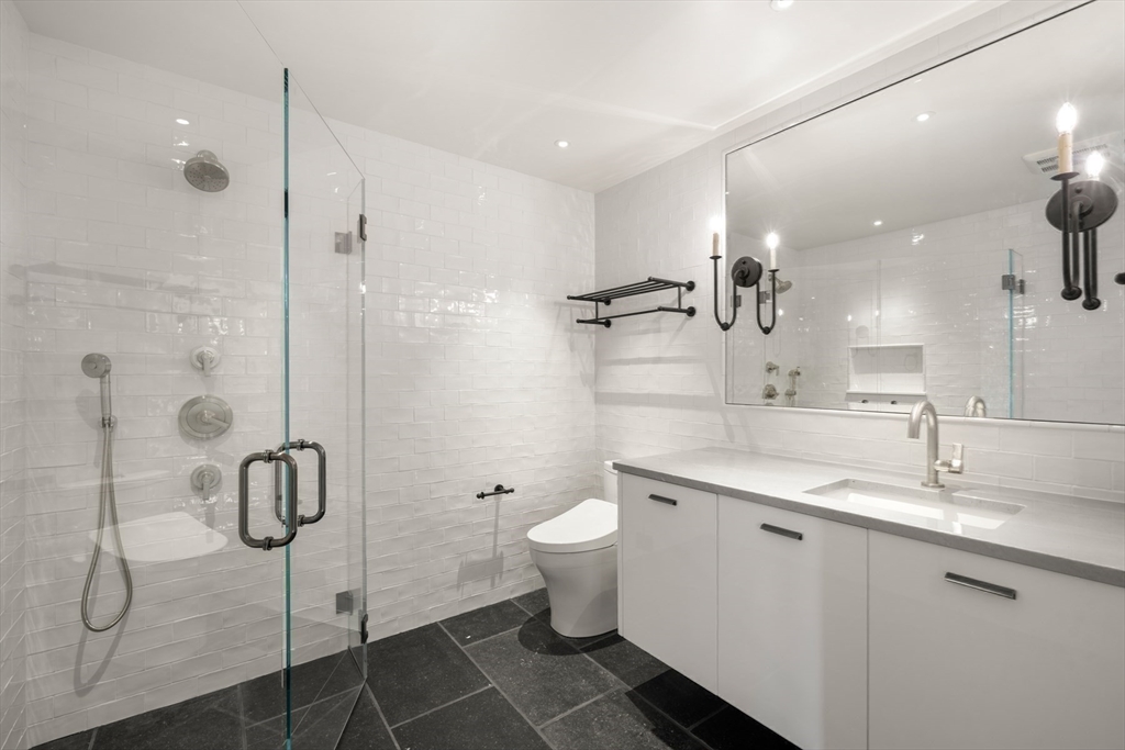 709 Boston Post Road Weston, MA 02493 - Photo 16 of 42 a bathroom with a double vanity sink toilet and shower