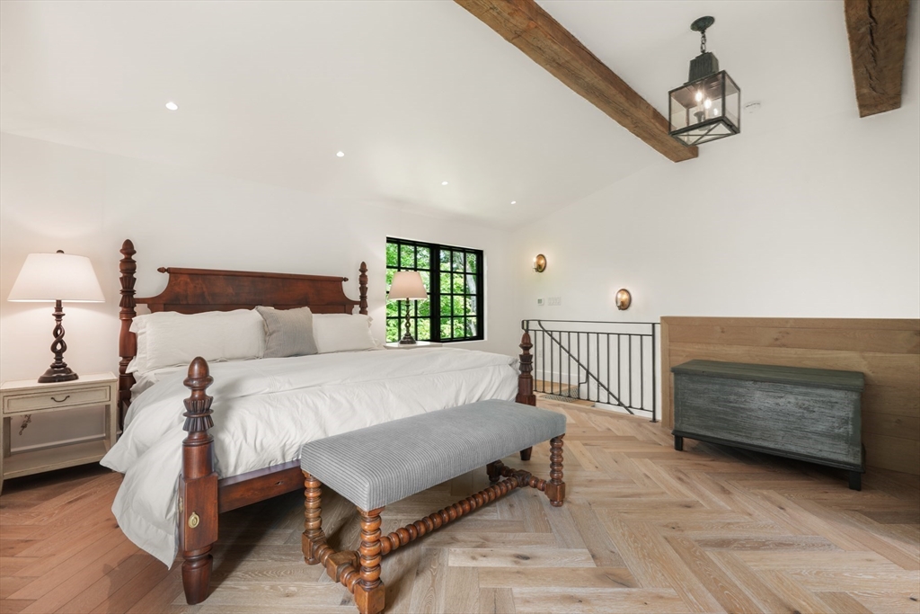 709 Boston Post Road Weston, MA 02493 - Photo 18 of 42 a bedroom with a bed a chandelier and mirror