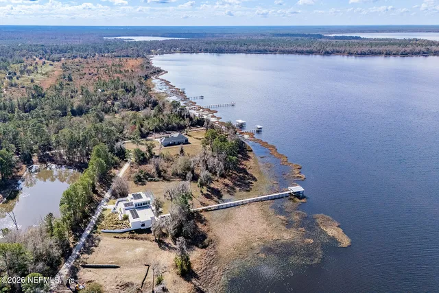 an aerial view of a house with a yard and lake view
