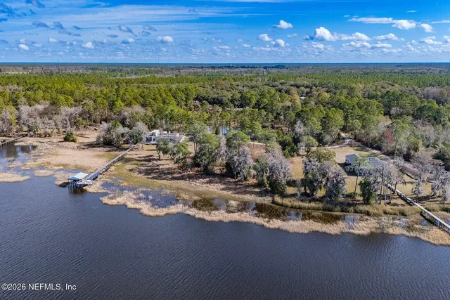 an aerial view of a house with a yard and lake view