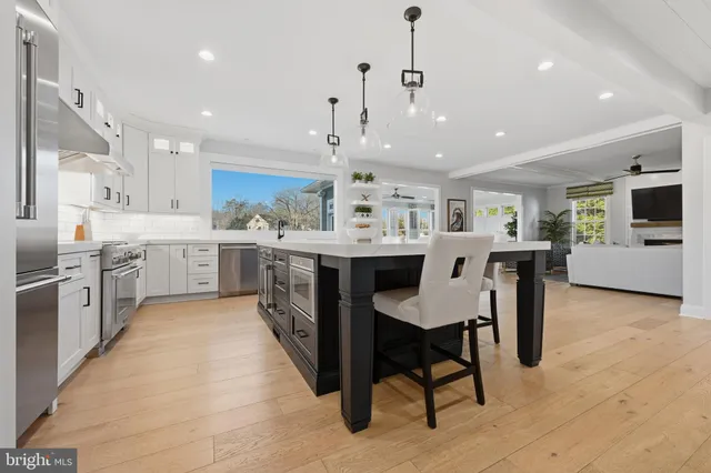 a dining room with furniture a chandelier and wooden floor