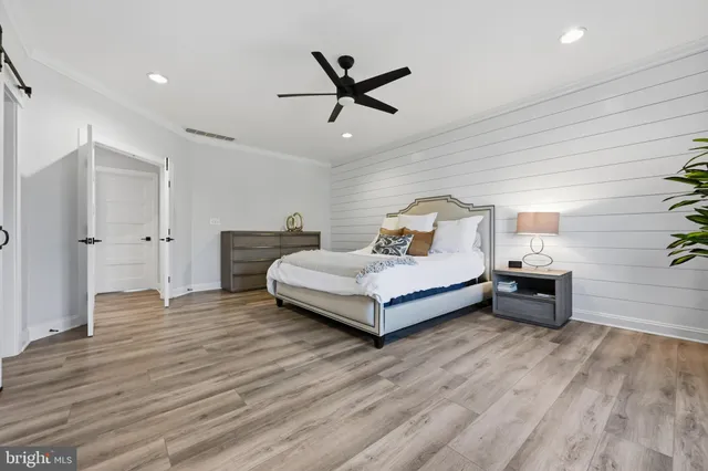 a bedroom with a bed and wooden floor