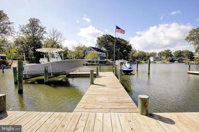 a living room with furniture kitchen view and a chandelier