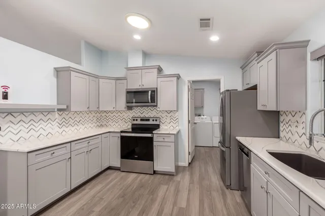 a kitchen with stainless steel appliances granite countertop a sink stove and refrigerator