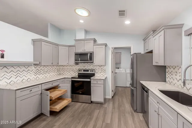 a kitchen with stainless steel appliances granite countertop a sink stove and refrigerator