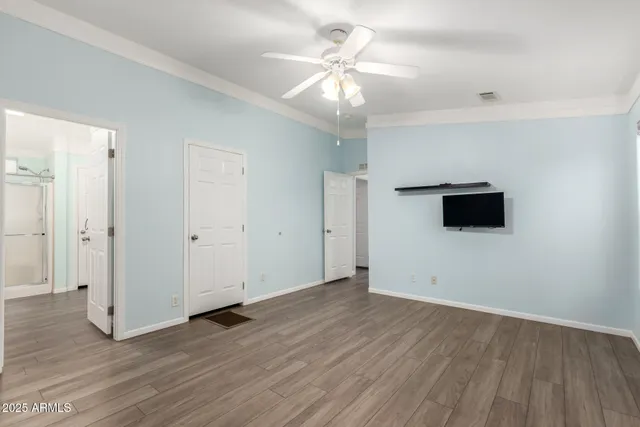 an empty room with wooden floor and windows