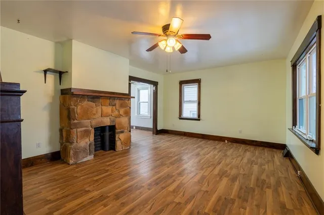 a view of an empty room with a fireplace and a window