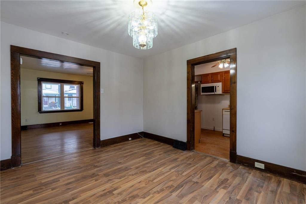 48 Sampson Avenue Pittsburgh, PA 15205 - Photo 5 of 18 an empty room with wooden floor chandelier and windows