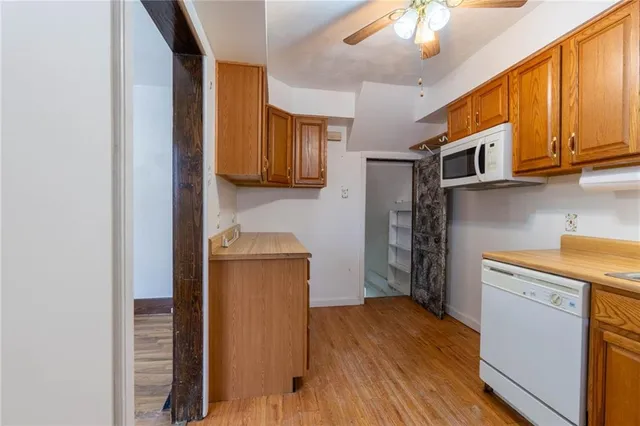 a kitchen with a refrigerator a stove cabinets and wooden floor