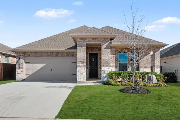 a front view of a house with a garden and plants