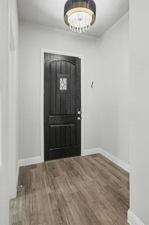 a kitchen with stainless steel appliances granite countertop a sink a stove a refrigerator and island with wooden floor