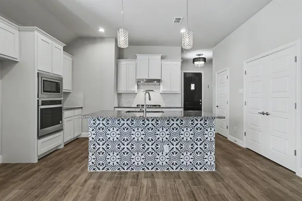 a kitchen with stainless steel appliances granite countertop a stove a sink and a refrigerator