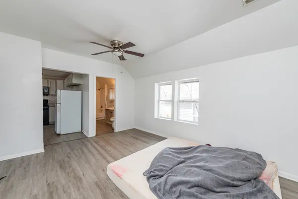 a bedroom with a bed and wooden floor