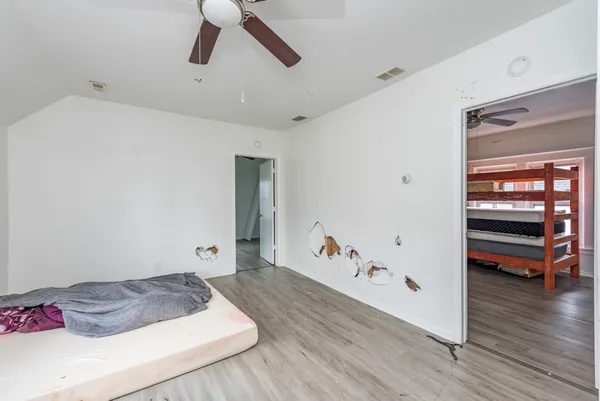 an empty room with wooden floor and windows