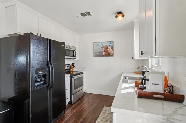 a kitchen that has a sink and cabinets with wooden floor