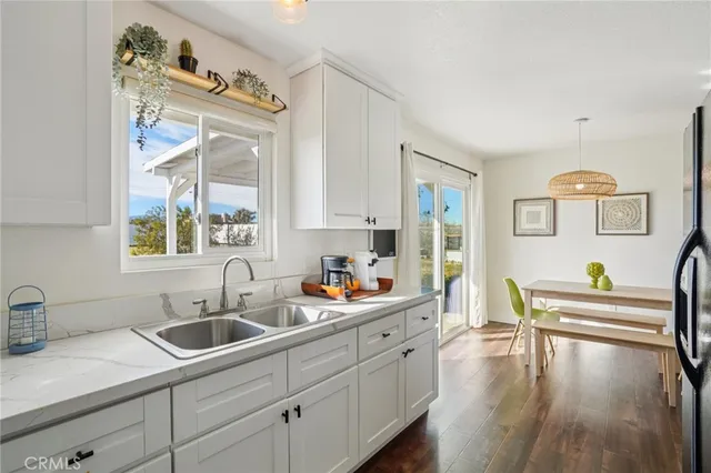 a kitchen with granite countertop white cabinets and stainless steel appliances