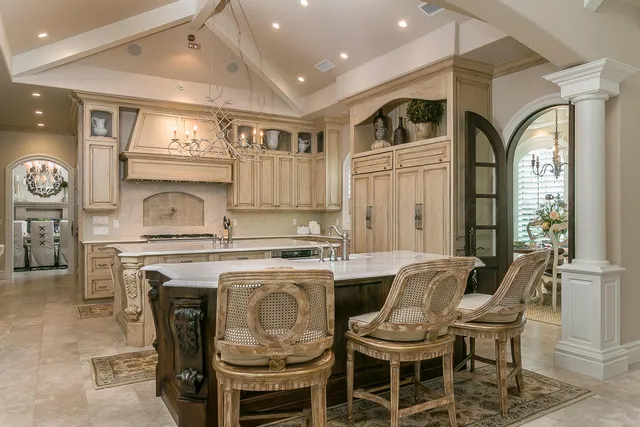 a dining hall with stainless steel appliances kitchen island granite countertop a sink and cabinets