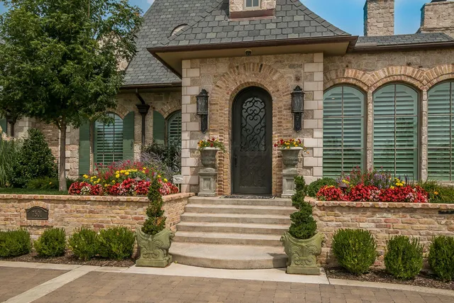 a view of a patio with table and chairs potted plants and a large tree