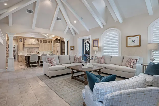 a kitchen with stainless steel appliances granite countertop a stove a refrigerator a dining table and chairs with wooden floor