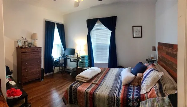 a bedroom with a bed and wooden floor