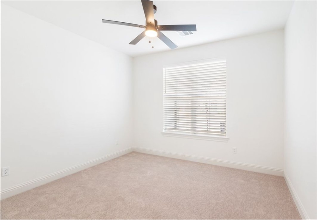 5102 Greenstone Way Bryan, TX 77802 - Photo 13 of 29 an empty room with a window and a fan