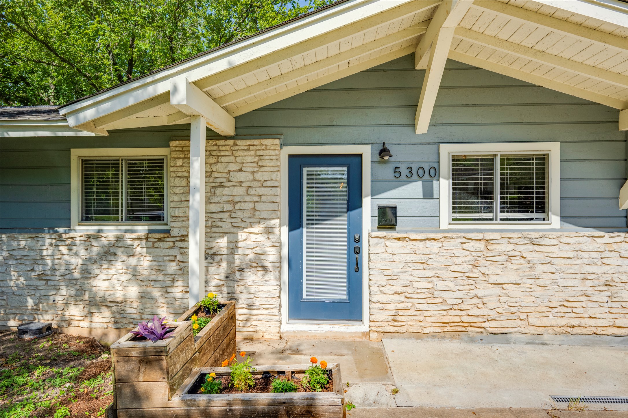5300 Halmark Drive Austin, TX 78723 - Photo 3 of 40 A charming exterior with stone accents and a vibrant blue door welcomes you.