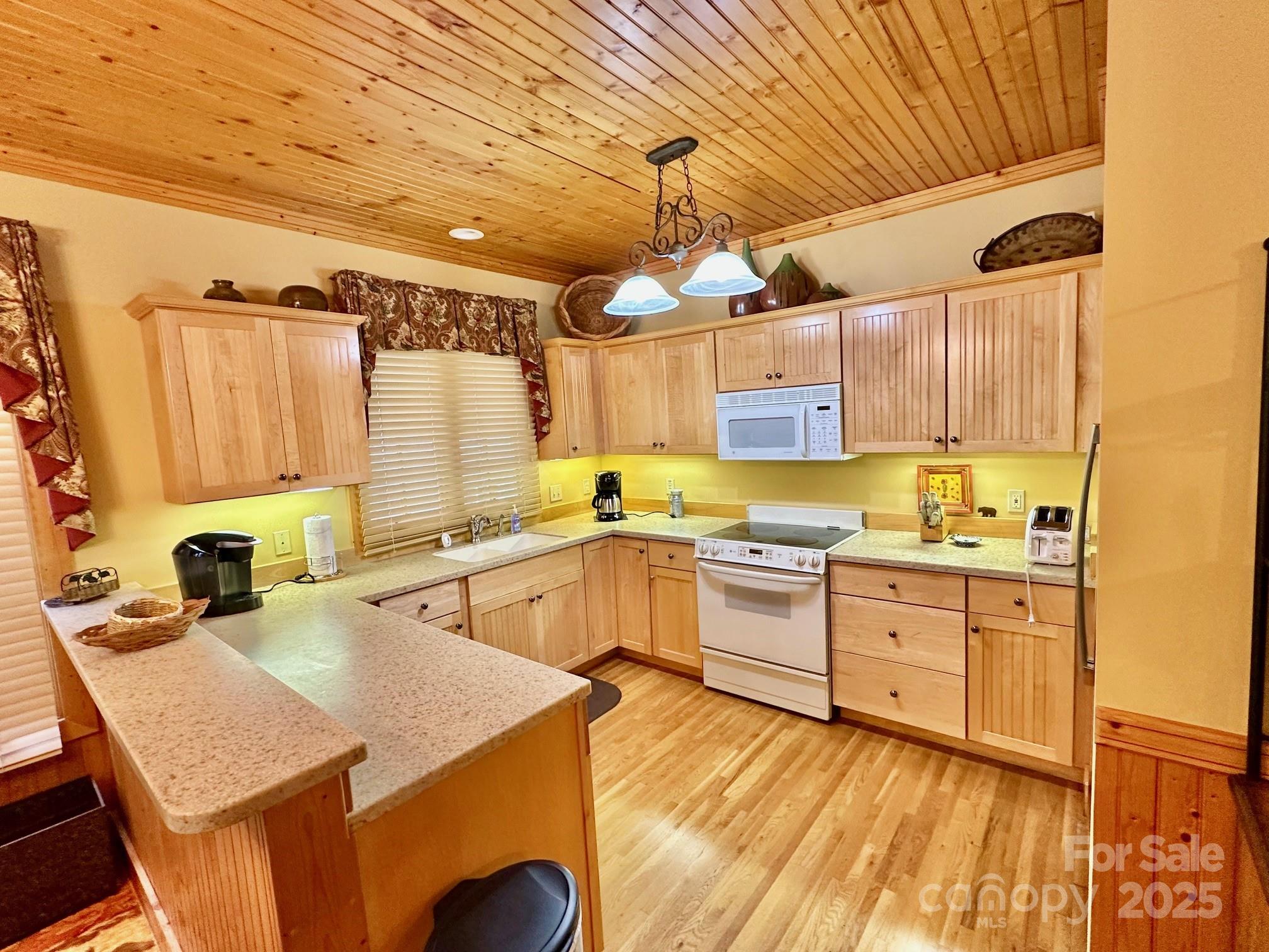 56 First Tee Trail Cashiers, NC 28717 - Photo 12 of 37 a kitchen with granite countertop a sink a stove and cabinets
