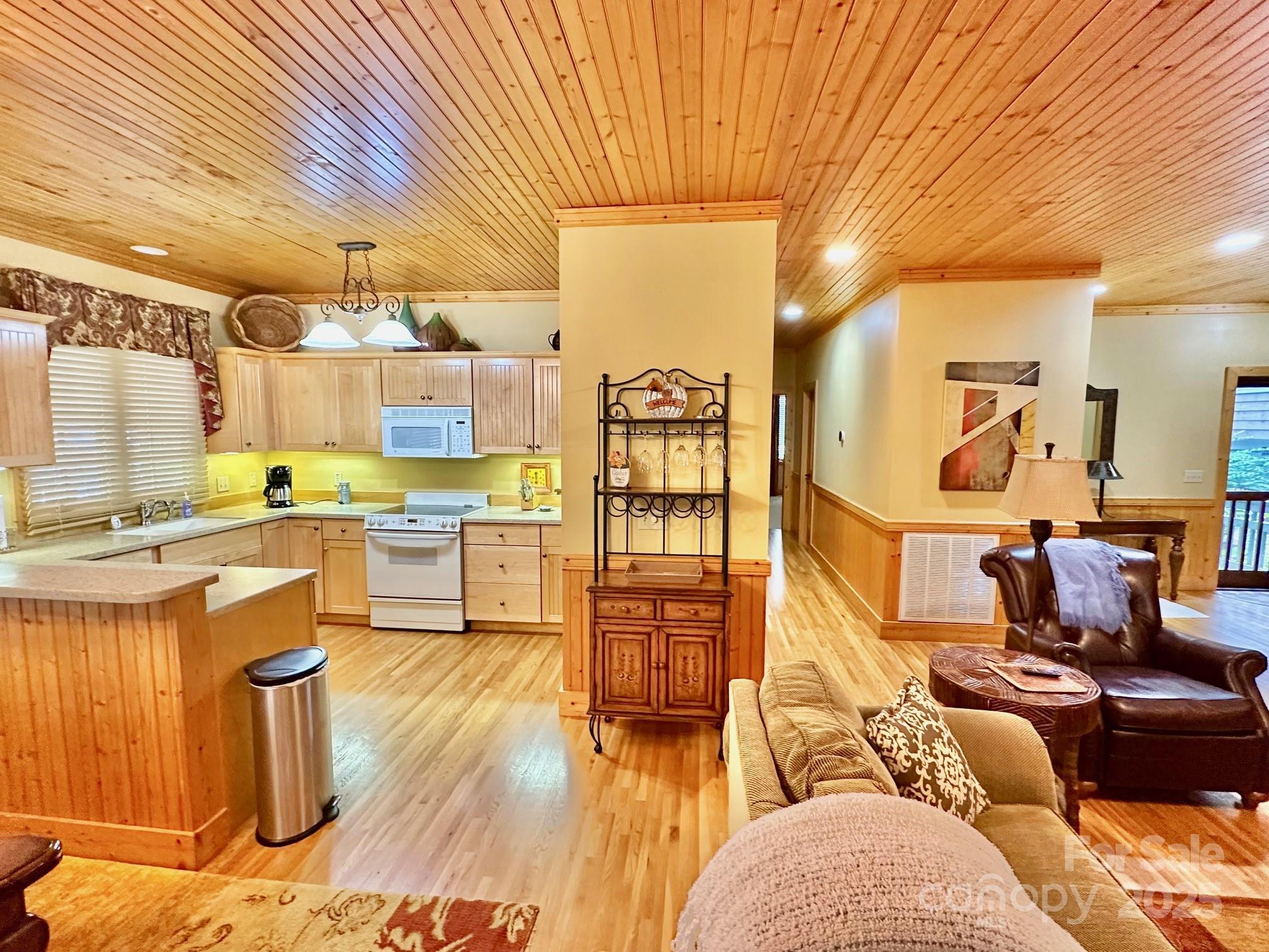 56 First Tee Trail Cashiers, NC 28717 - Photo 13 of 37 a living room with couches and kitchen view with wooden floor