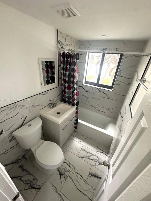 7035 Rue Granville Miami Beach, FL 33141 - Photo 11 of 12 a bathroom with a toilet sink and mirror