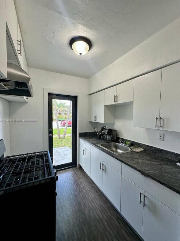 7035 Rue Granville Miami Beach, FL 33141 - Photo 5 of 12 a kitchen with granite countertop a stove and a sink