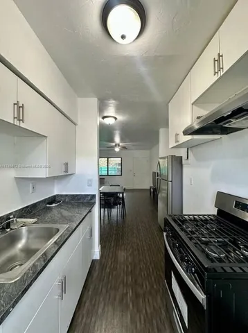 a kitchen with granite countertop a stove and a sink
