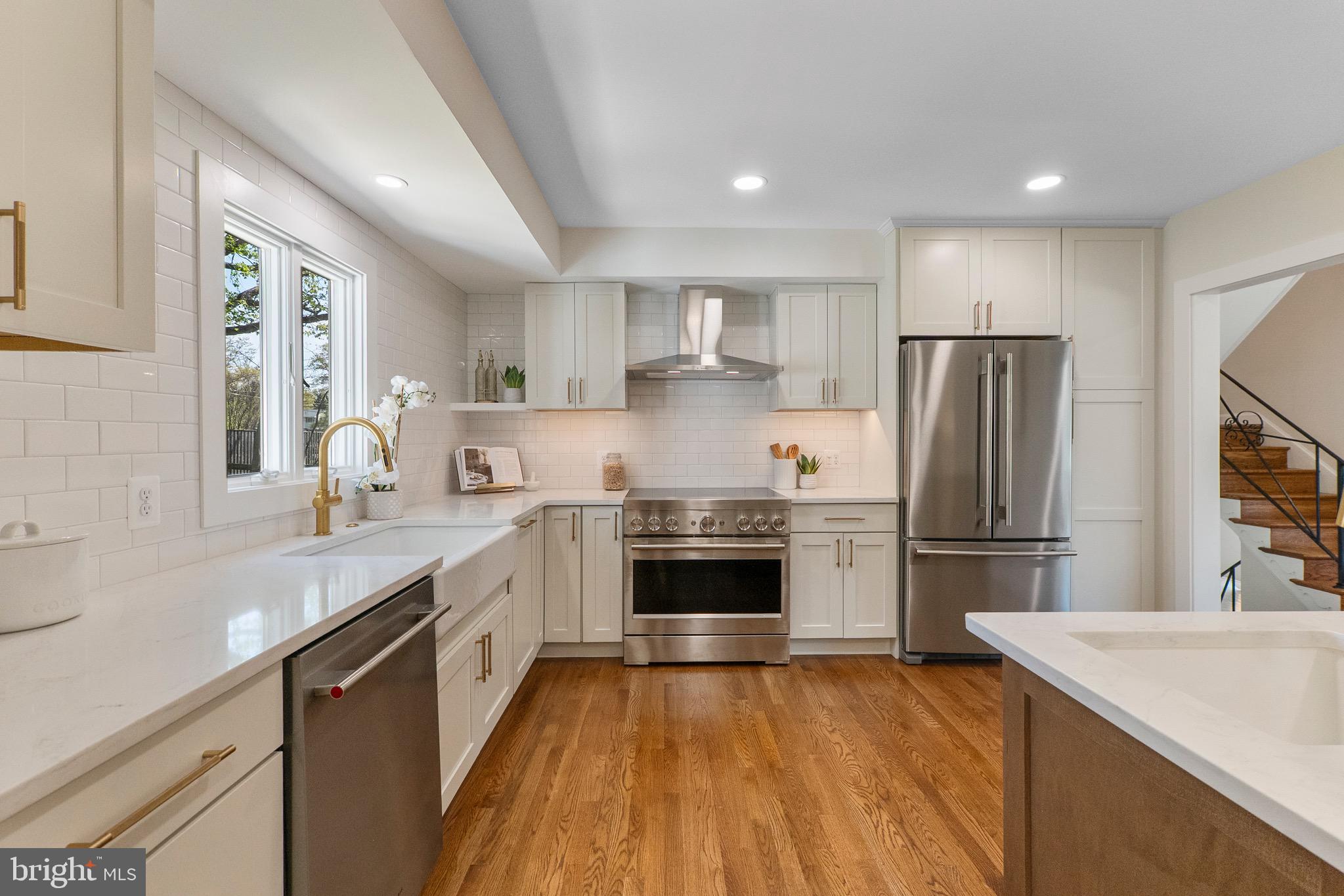 3003 Farm Road Alexandria, VA 22302 - Photo 10 of 49 a kitchen with a sink a refrigerator and a stove top oven with wooden floor