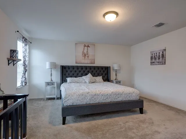 a spacious bedroom with a bed and a night stand