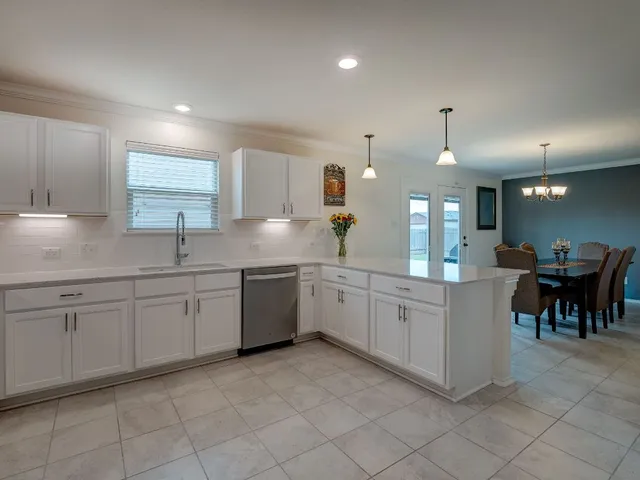 a large white kitchen with a large window