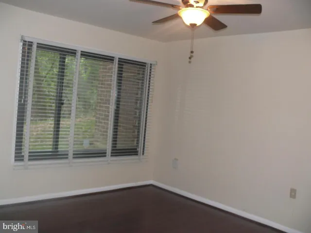 a view of wooden floor and a chandelier fan
