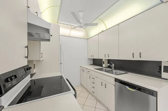 a kitchen with a sink dishwasher and white cabinets