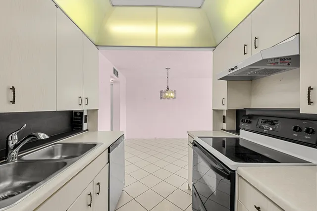 a kitchen that has a sink a stove and cabinets