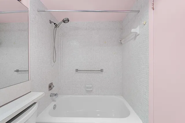 a bath tub sitting next to a white sink and vanity
