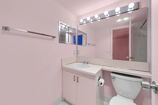 a bathroom with a toilet sink and mirror